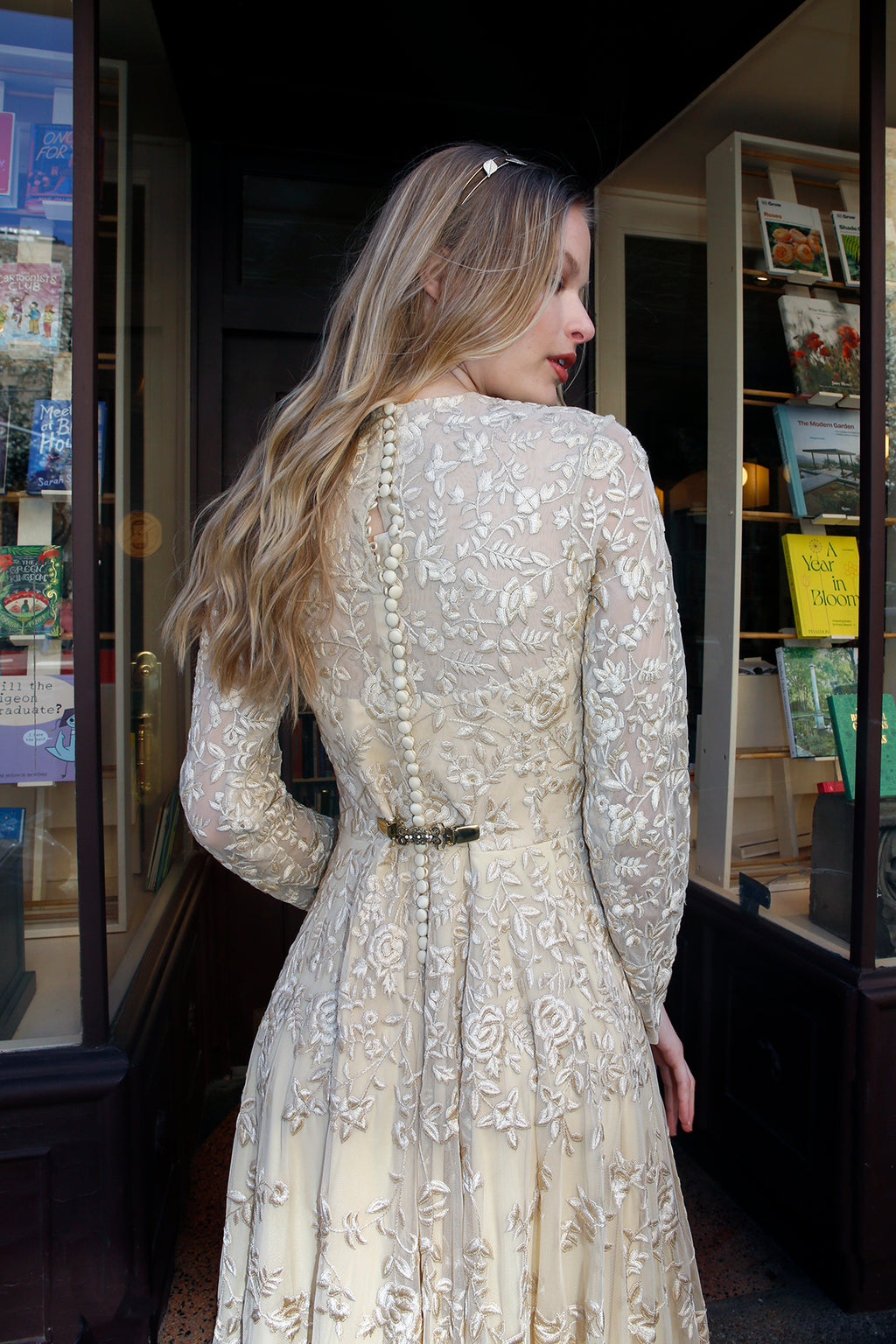 Rear view of the Olympia couture evening gown by Lavanya Coodly showing the embroidered sheer back, long sleeves and flowing tulle skirt.