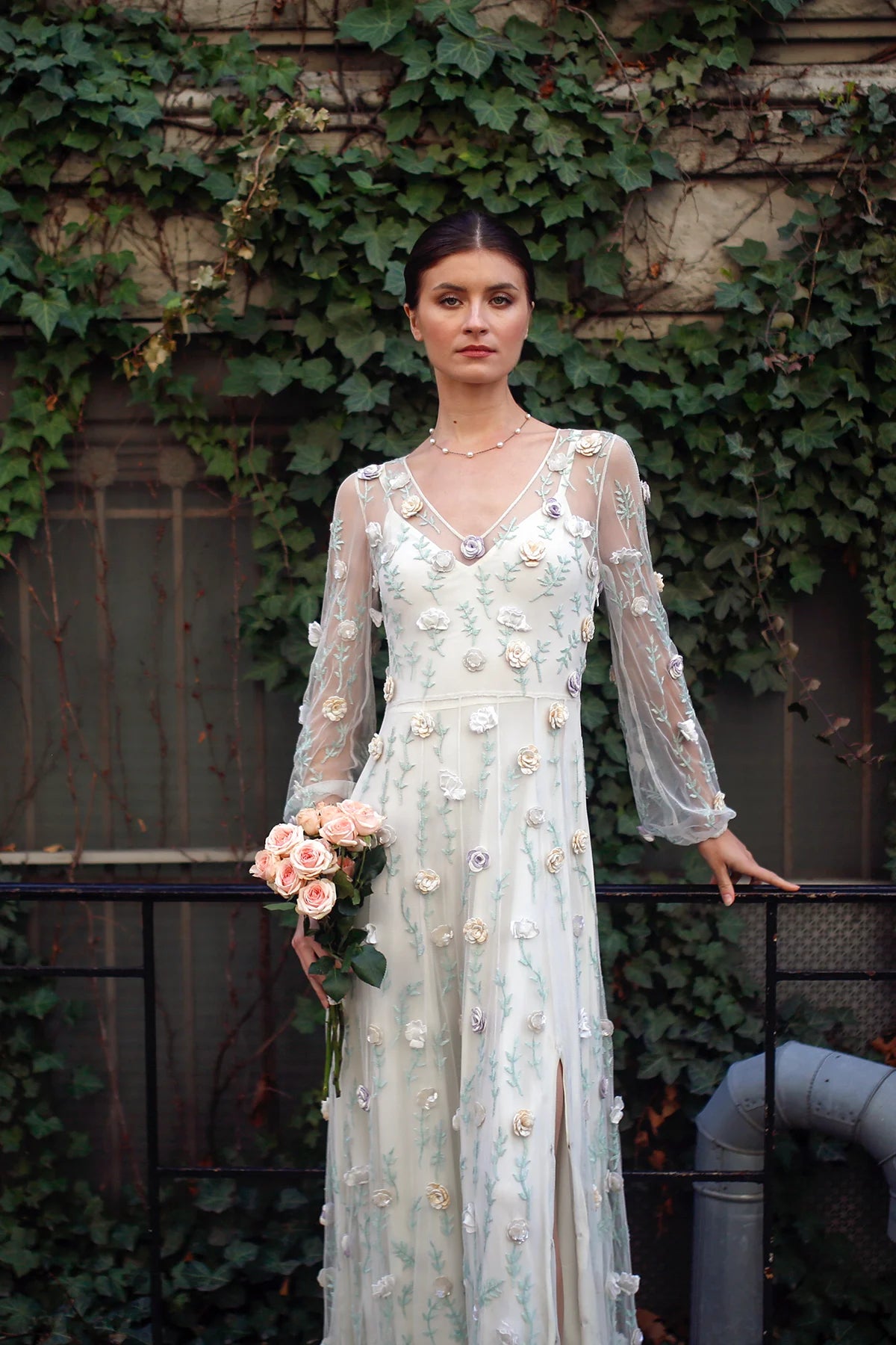 Rosalind gown by Lavanya Coodly with 3D floral appliqués, sheer long sleeves and V-neckline
